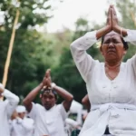 a group of people dressed in white kneeling and praying