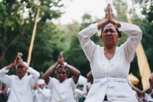 a group of people dressed in white kneeling and praying