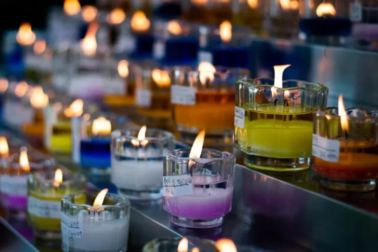Line of multi-coloured candles in glasses