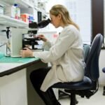 A scientist practicing her vocation in the laboratory through a microscope