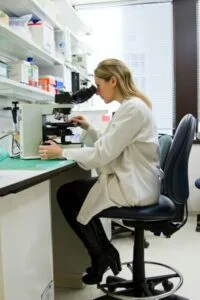 A scientist practicing her vocation in the laboratory through a microscope