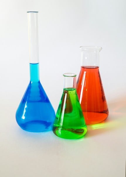 three science flasks with blue green and red liquids