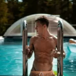 a male model climbing out of a swimming pool