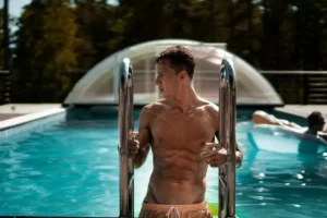 a male model climbing out of a swimming pool