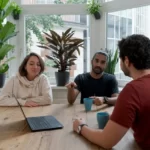 a group of stakeholders sitting around a table with a laptop