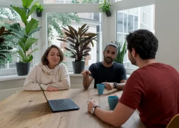 a group of stakeholders sitting around a table with a laptop