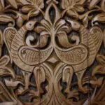 A wood carving of two birds animism