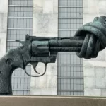 A statue of a revolver with the barrel twisted into a knot. Symbolic violence.
