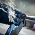The Barrell of a just fired shotgun with smoke exiting - symbolic violence media