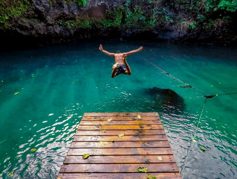 A man taking action by diving into a lagoon