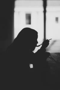 A silhouette of a woman eating with a spoon