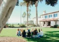 A group of people sitting in a circle at a commune on a sunny day