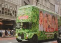 A green bus with members of a K-Pop band on the side