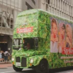 A green bus with members of a K-Pop band on the side