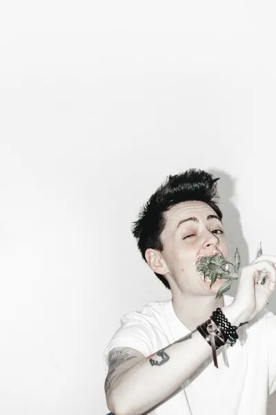 A ladette eating flowers against a white background