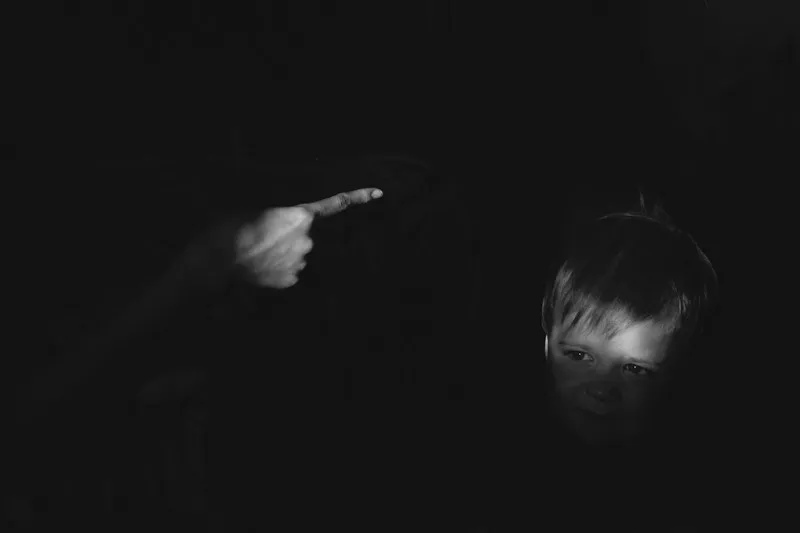 A blacked out image of a finger waving at a naughty child