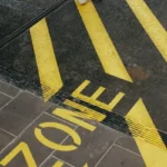 a floor marking in yellow stating 'zone'