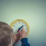 A young boy playing with a clock.