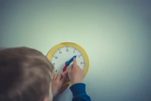 A young boy playing with a clock.