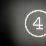 The number four in white with a circle around it against a black and grey background