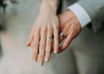 A male and female hand showing their wedding rings