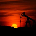 Oil drilling equipment in silhouette at sunset