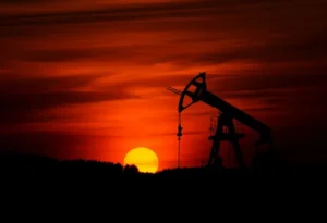 Oil drilling equipment in silhouette at sunset