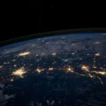 A shot of earth at night from space showing cities lit up.