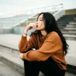 A woman sat on stairs thinking cognitively