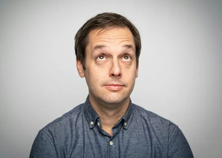 A man against a grey background thinking cognitively