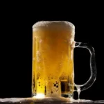 A stein of golden beer against a black background