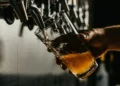 A pint of beer being poured from a beer tap