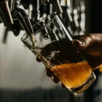 A pint of beer being poured from a beer tap