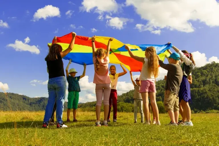 A group of children with a large flag on a sunny day