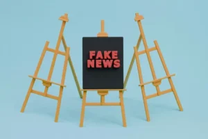 three minature easels with the middle one saying fake news