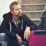 A man with a purple suitcase experiencing divorce