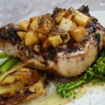 A dish of pork fillet topped with swede and accompanied by a side of broccoli