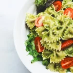 Farfalle pasta with tomato and green leaves