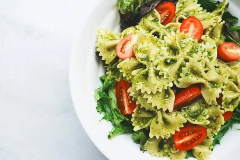 Farfalle pasta with tomato and green leaves