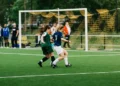 Two football soccer players playing football on a pitch