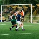 Two football soccer players playing football on a pitch
