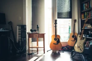 An apartment with sunlight shining through the window onto two acoustic guitars
