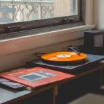 A record player playing an orange vinyl