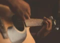 A close up of somebody strumming a guitar