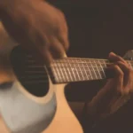 A close up of somebody strumming a guitar