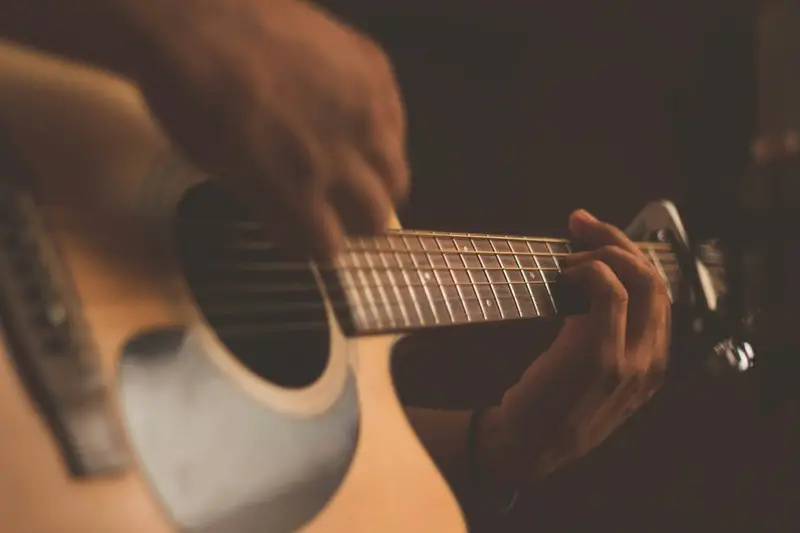 A close up of somebody strumming a guitar
