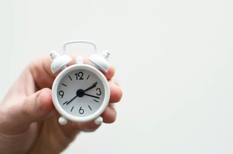 A miniature white alarm clock
