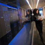 A woman on a laptop inside a data center