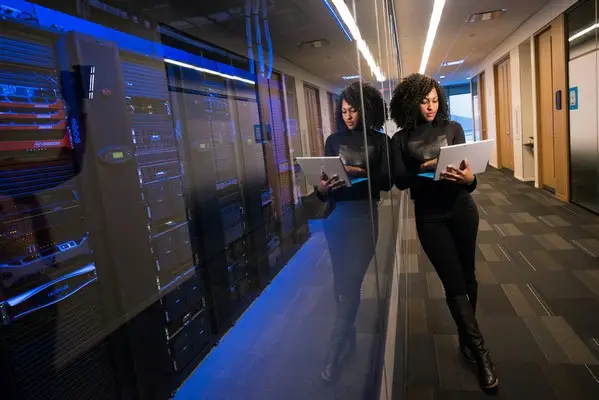 A woman on a laptop inside a data center