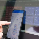 A finger pointing at economic data on a phone